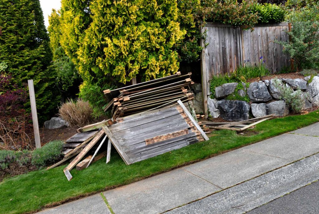 Old wooden fence panels, just removed and laying in a heap on the side of the road